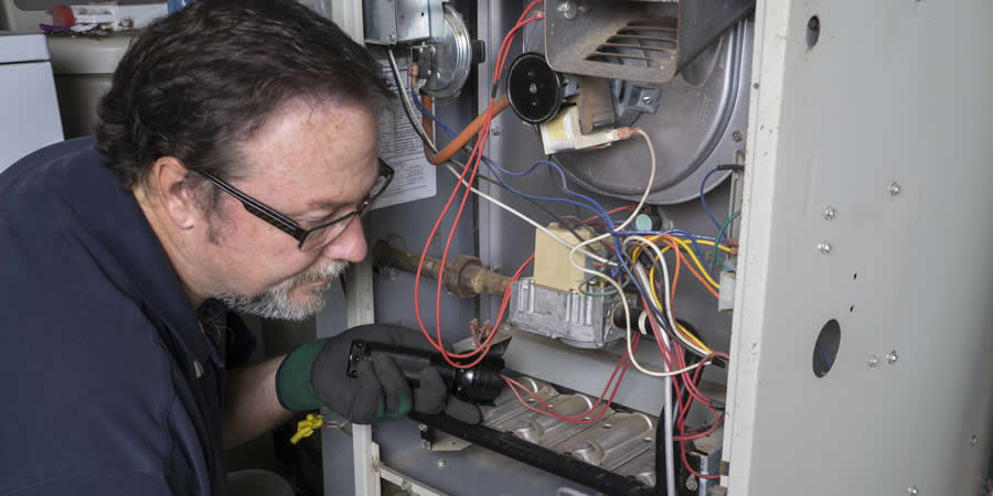 hvac tech repairing furnace